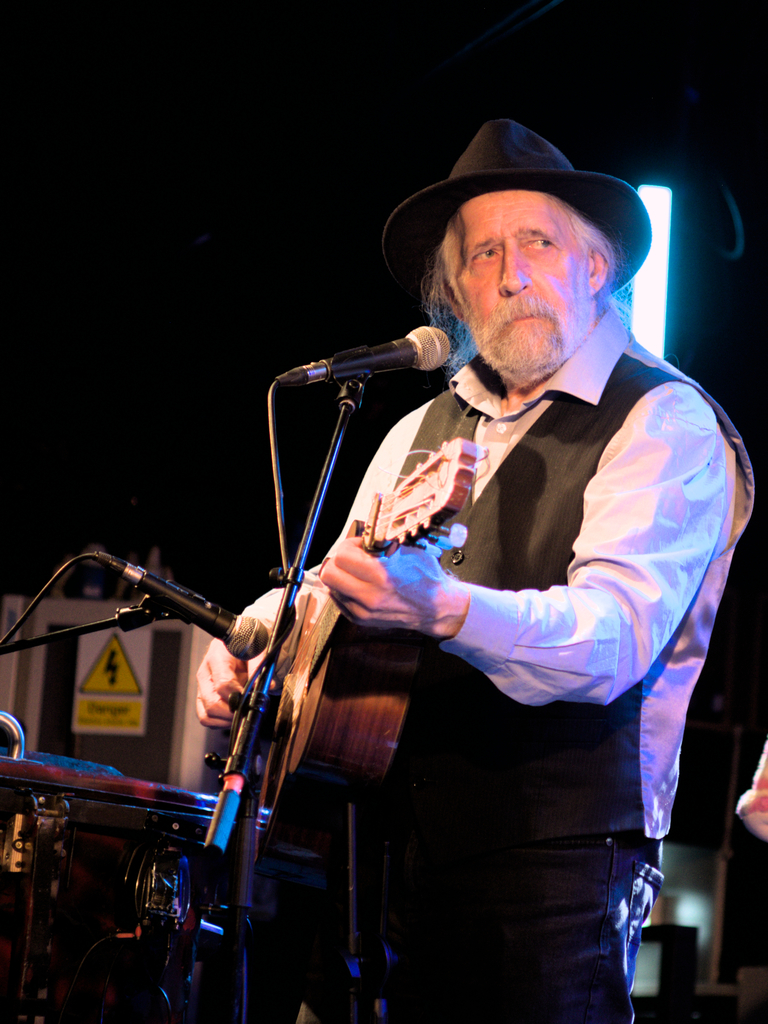 Willy Barrett playing guitar whilst looking skeptical